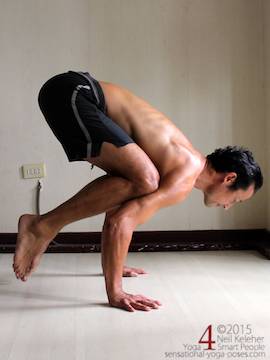 balancing in bakasana, with knees resing on the backs of the arms