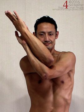 Eagle arm position shoulder stretch, forearms tipped to one side.  neil keleher, sensational yoga poses.