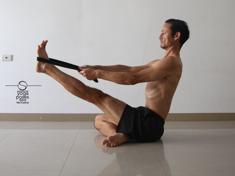 seated hamstring stretching yoga pose with leg lifted and using a belt. Neil Keleher, Sensational Yoga Poses.