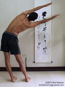 moon pose, chandrasana, standing side bend with feet hip width and arms reaching over the head. Arms are shoulder width apart