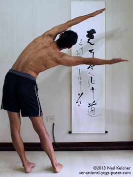 moon pose, chandrasana, standing side bend with feet hip width and arms reaching over the head. Arms are wider than shoulder width