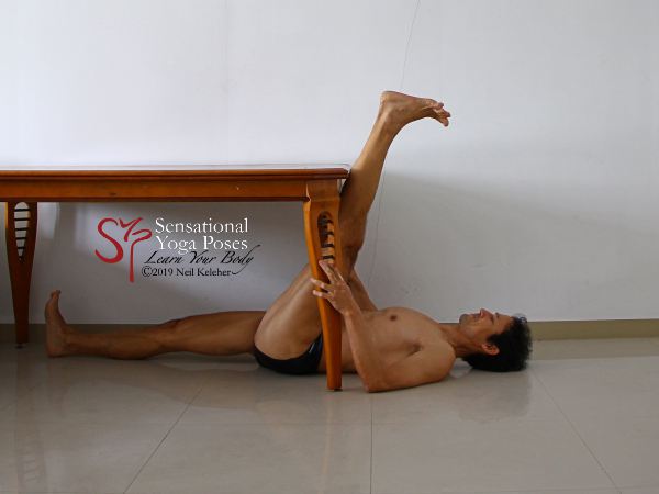 An alternative to lying with feet up a wall is to lie under a table with a foot resting against the edge of the table. You can use this as an easy way to stretch your hamstrings. Neil Keleher. Sensational Yoga Poses.