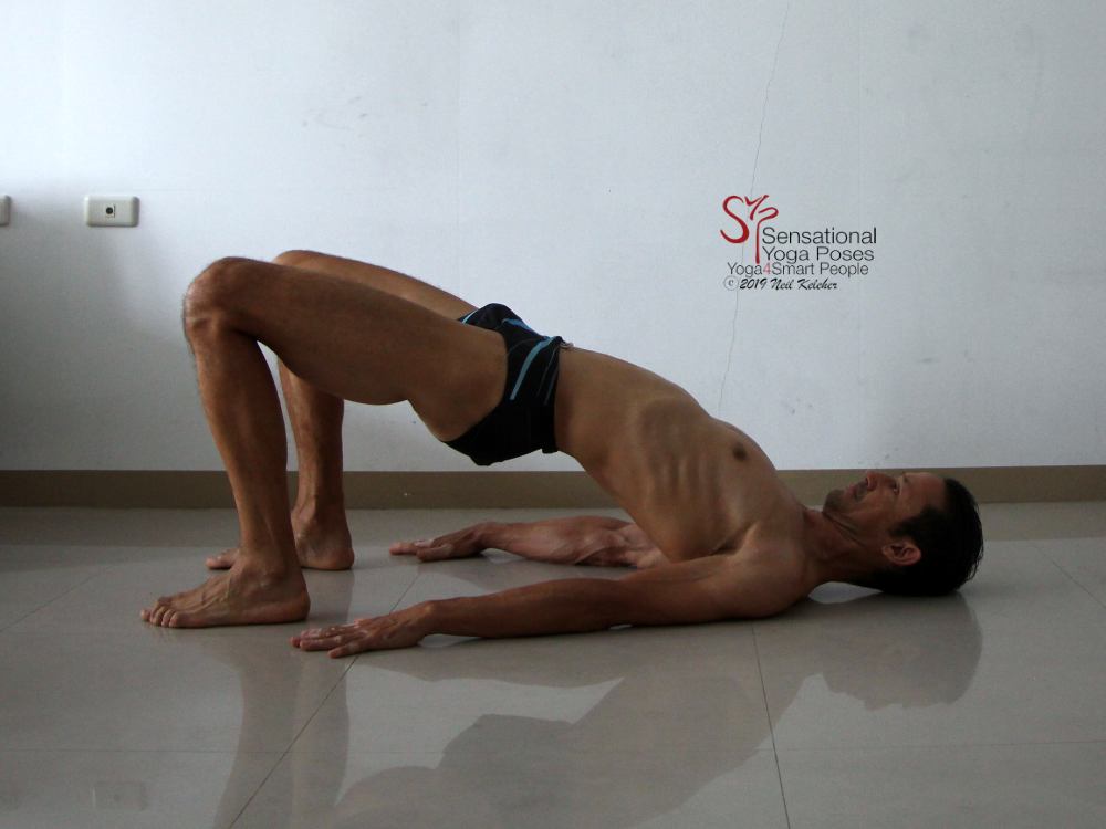 In bridge pose with hips lifted, and belly relaxed. This is in preparation for activating the transverse abdominis. Neil Keleher, Sensational Yoga Poses.