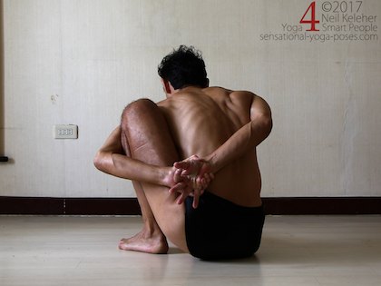 Grabbing a hand behind the back to bind in marichyasana a yoga pose. Neil Keleher. Sensational Yoga Poses.