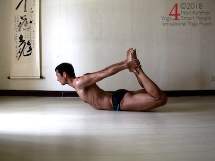 bow pose. From a prone/belly down position, grab the ankles from behind the back. Pull back with your feet to help lift your chest. At the same time lift your knees.