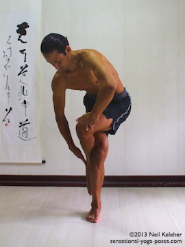 Sensational Yoga Poses, Model Neil Keleher. balancing on one leg while moving into eagle pose with lifted foot in front of the standing leg knee.