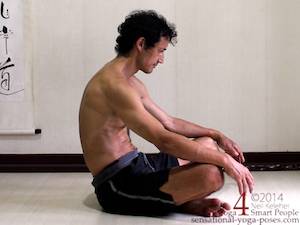 Seated spinal forward bend with legs crossed.