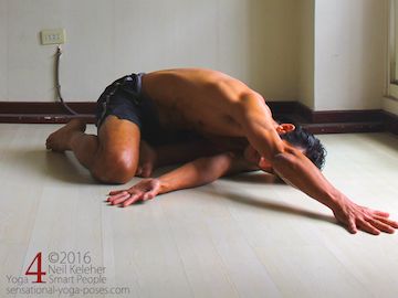 yoga shoulder stretch while bent forwards using the easy bharadvajasana foot position (semi kneeling position.)