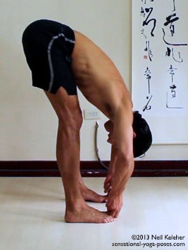 ashtanga yoga poses, standing yoga poses, padangusthasana, big toe pose. Side view. In this standing forward bend the feet are hip width apart and parallel. Knees are straight and the upper body is tilted forwards at the pelvis. The first two fingers and thumb of each hand are used to grab the big toes of both feet. Gaze is downwards towards the feet. Model, Neil Keleher, Sensational Yoga Poses.