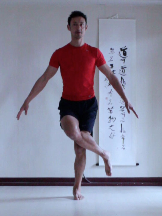 preparation for eagle pose, bending the knees and crossing the legs