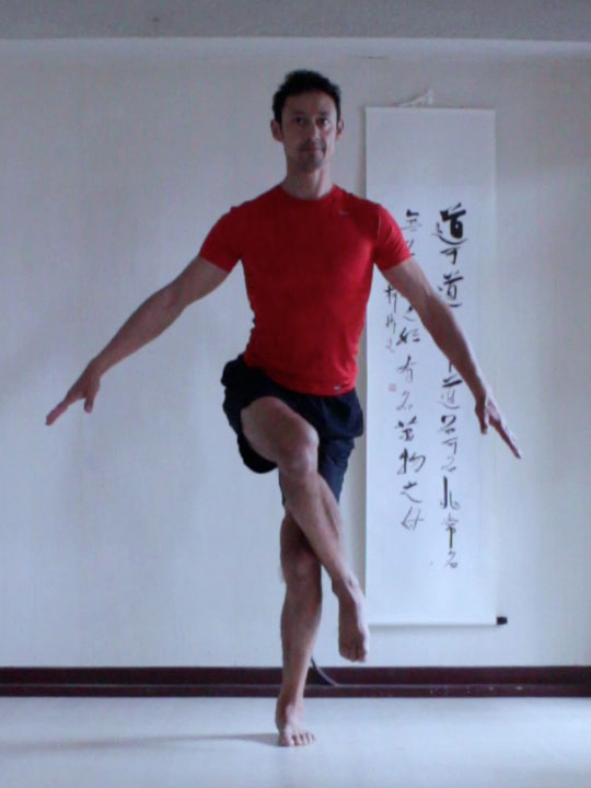 preparation for eagle pose, lifting one hip withlegs crossed