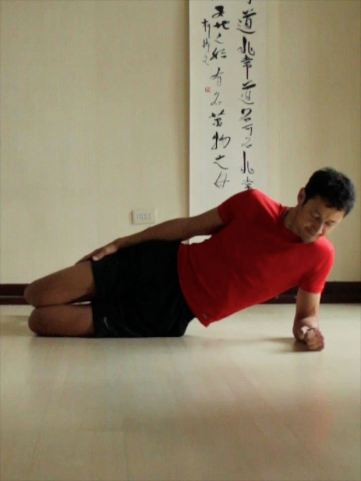 Preparing for Side Plank or vasisthasana with knees and elbows bent, hips on the floor