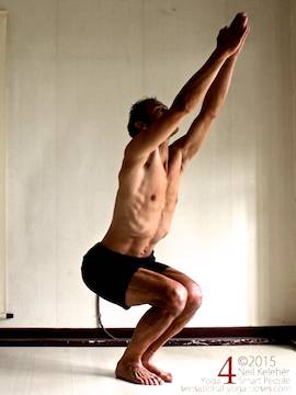 utkatasana or chair pose with arms reaching up and feet together.