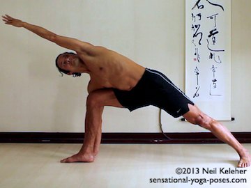 ashtanga yoga poses, utthitta parsvokonasana, side angle yoga pose right side. In right side angle pose the right foot is turned out 90 degrees. The right knee is bent so that the this is levela nd shin vertical. Left knee is straight with left foot turned in slightly. Left left, left side of the body form one straight line that reaches over the head. Right hand touches the floor outside the right foot with elbow straight.
