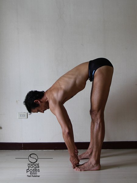 Standing forward bend with knees straight and first two fingers and thumbs grabbing the big toes (padangusthasana). Neil Keleher. Sensational Yoga Poses.