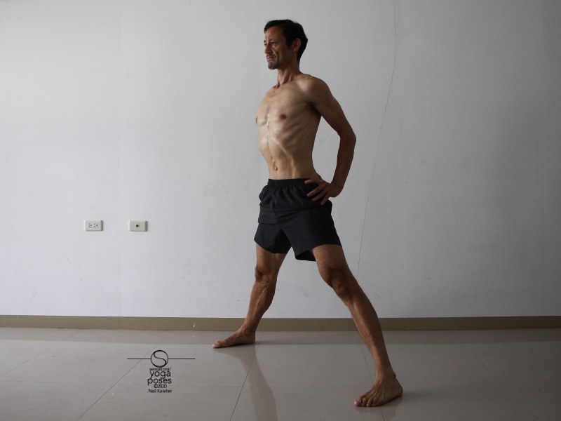 Prep position for wide leg standing hamstring stretch with hands on waist (prasaritta padotanasana B). Lift chest and retract your shoulder blades. Neil Keleher, Sensational Yoga Poses.
