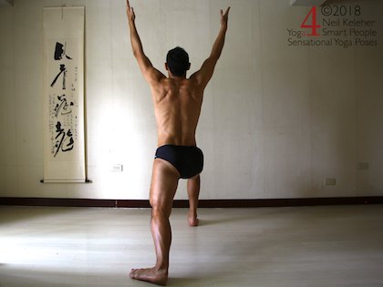 Warrior 1 standing yoga pose with hands apart and shoulders lifted. Neil Keleher. Sensational Yoga Poses.