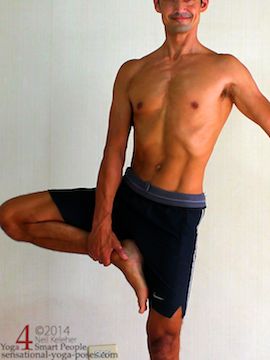 Yoga tree pose, using a hand to help position the foot higher on the inner thigh. Neil Keleher. Sensational Yoga Poses.