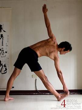 triangle pose, utthitta trikonasana while holding big toe with forefoot lifted Neil Keleher. Sensational Yoga Poses.