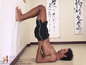 shoulderstand against wall, hips lifted, hands supporting lower back